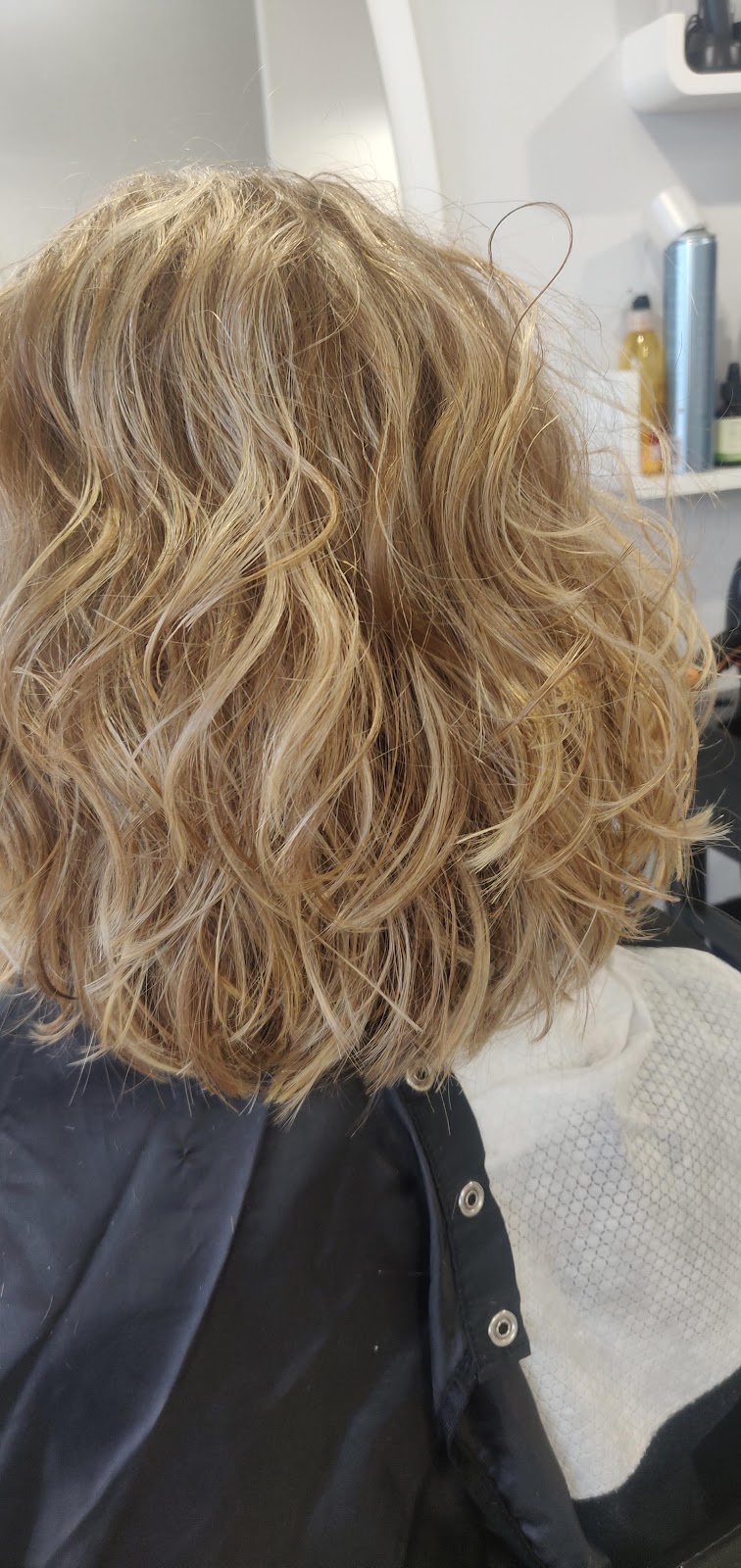 Blond włosy w falach z rozświetlonymi pasmami po koloryzacji